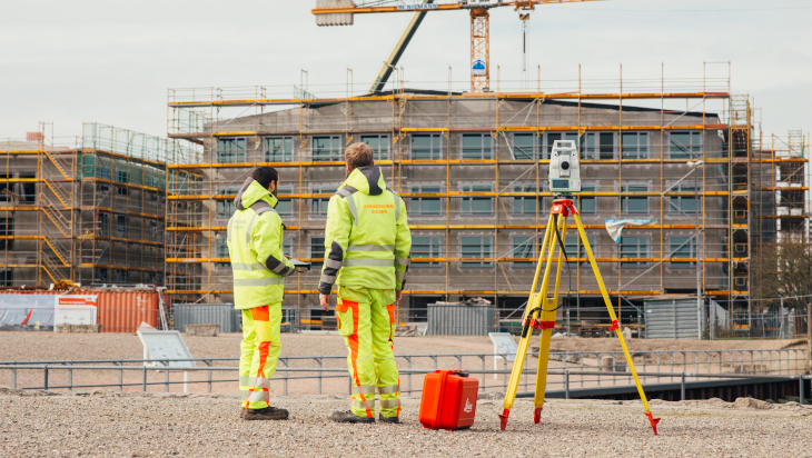 Vermessungsingenieure bei der Durchführung einer Absteckung auf einer Baustelle in Rostock
